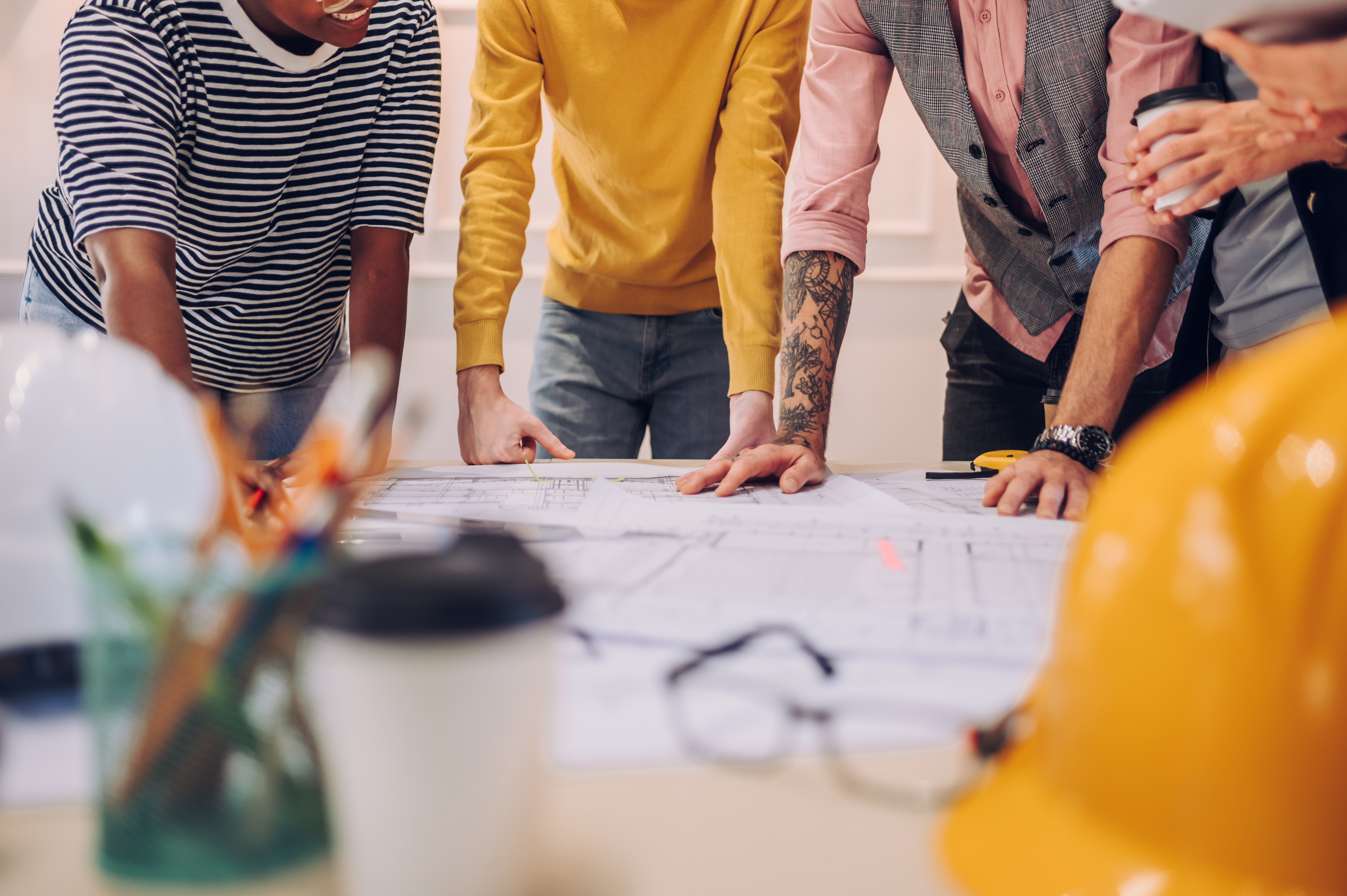 Multiracial team of architects having a meeting while using blue