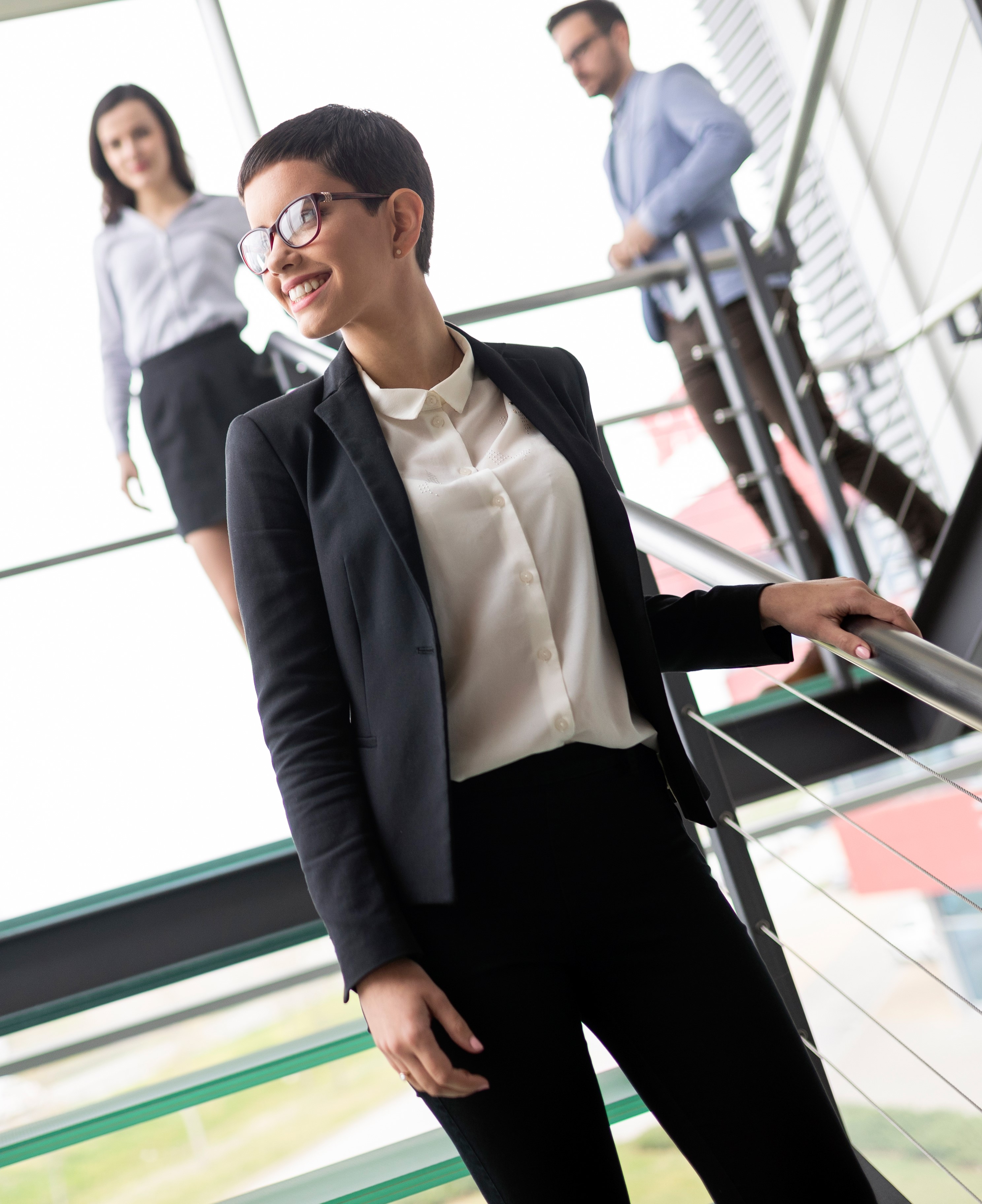Modern business people walking on stairs in glass hall of office building